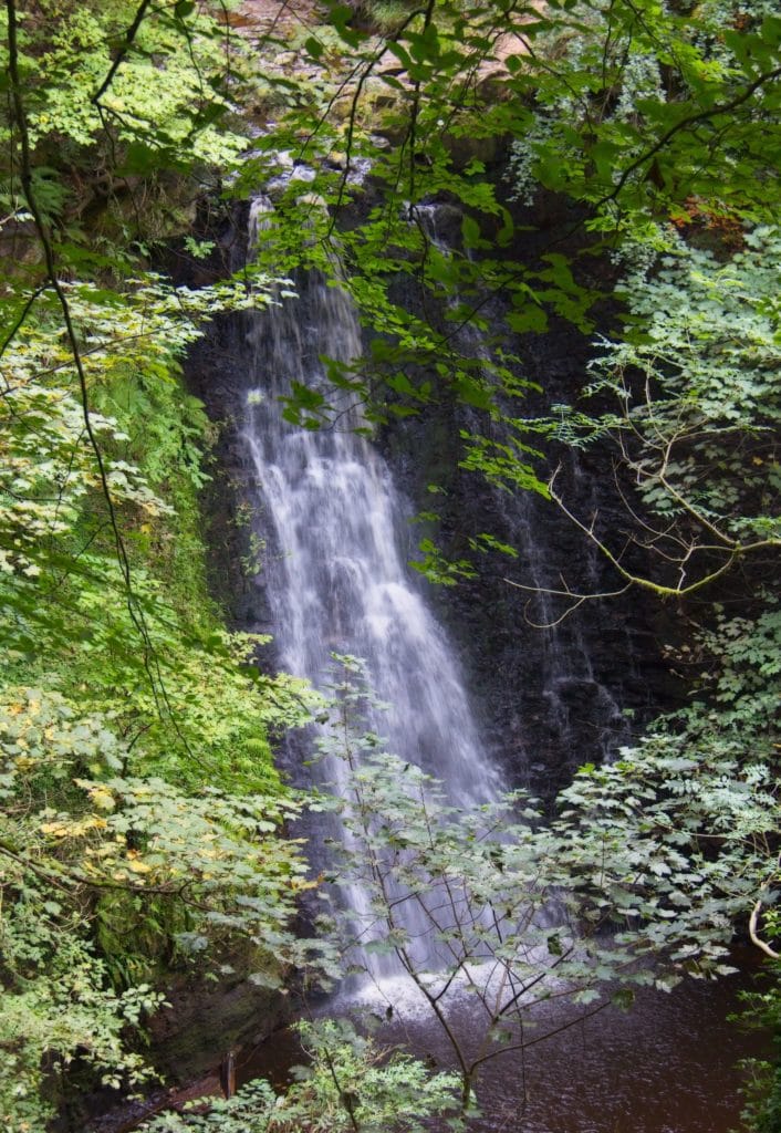 A view of famous Falling Foss Waterfall through the trees in North Yorkshire. Goathland, North Yorkshire, England